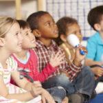 group of elementary age schoolchildren in music class with instruments